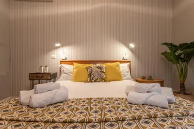 a bedroom with a large bed with two chairs on it at Kitty Apartment - Close to the Vatican in Rome