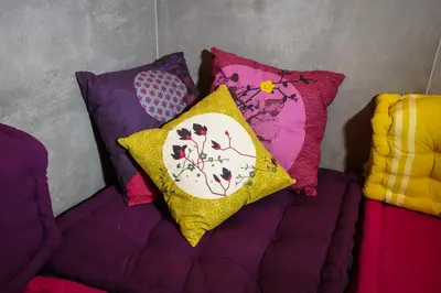 a couch with four pillows on it next to a wall at Rosso Cortese in Rome