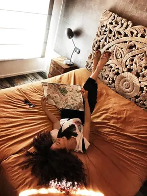 a woman laying on a bed reading a book at Rosso Cortese in Rome