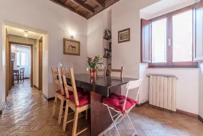a kitchen and dining room with a table and chairs at By the charming Piazza Navona - FromHometoRome in Rome