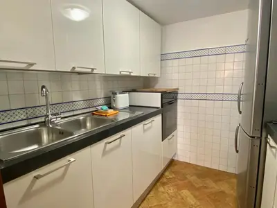 a kitchen with white cabinets and a sink at By the charming Piazza Navona - FromHometoRome in Rome