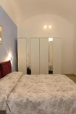a bedroom with a large bed with white walls at Domus Vatican Museum in Rome