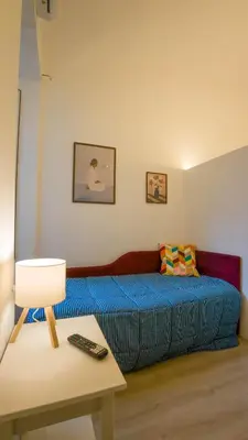 a bedroom with a bed and a table with a remote control at Domus Vatican Museum in Rome