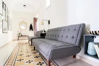 a living room with a gray couch and a rug at Casa di Artemisia in Rome