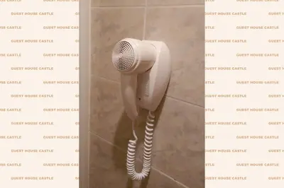 a white phone hanging on a wall in a bathroom at Roma Castle Termini in Rome