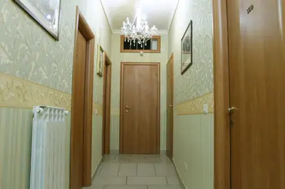 a hallway with a door and a chandelier at Roma Castle Termini in Rome