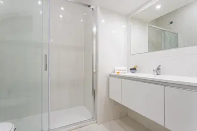 a white bathroom with a shower and a sink at Design Suite Trevi Fountain in Rome