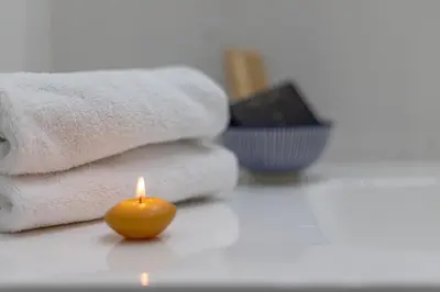 a candle sitting on a table next to towels at Design Suite Trevi Fountain in Rome