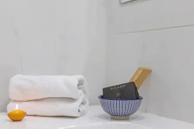 a bathroom with towels and a book on a counter at Design Suite Trevi Fountain in Rome
