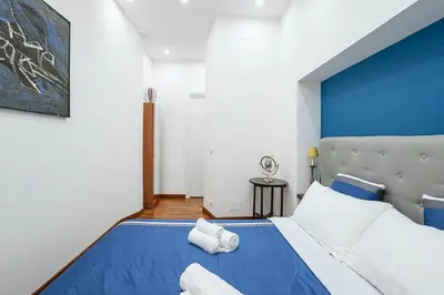 a blue and white bedroom with a large bed at Design Suite Trevi Fountain in Rome