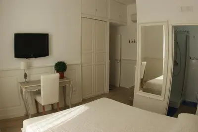 a bedroom with a bed and a table and a tv at Alba Sul Vaticano in Rome