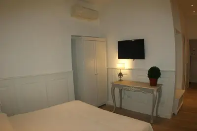 a bedroom with a bed and a table with a tv on the wall at Alba Sul Vaticano in Rome