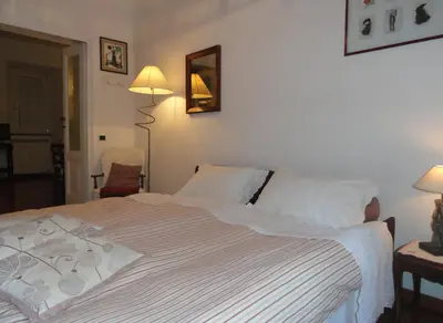 a bedroom with a bed with white sheets and two lamps at Il nido al Colosseo in Rome