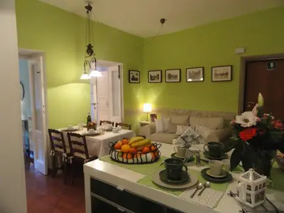 a kitchen with green walls and a table with fruit on it at Il nido al Colosseo in Rome