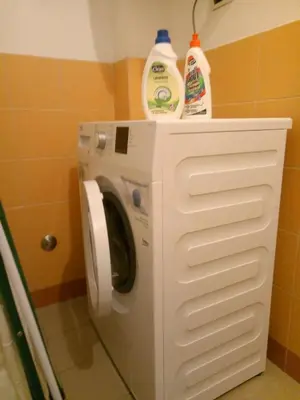 a washing machine with two bottles of detergent on top of it at Il nido al Colosseo in Rome