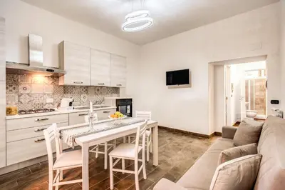 a kitchen and living room with a table and a couch at Laura luxury apartment in the center Rome in Rome