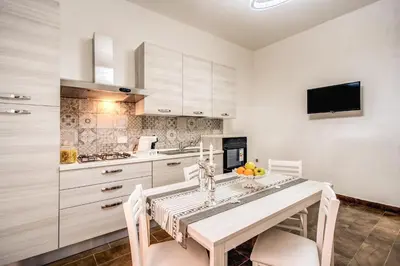 a kitchen with white cabinets and a table and chairs at Laura luxury apartment in the center Rome in Rome