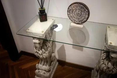 a glass table in a room with a statue at TimeRoma in Rome