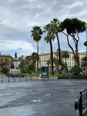 a street with palm trees in front of a building at TimeRoma in Rome