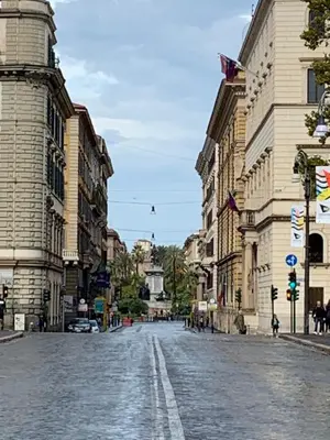 an empty street in a city with buildings at TimeRoma in Rome