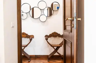 a mirror in a room with a chair and mirrors on the wall at TimeRoma in Rome