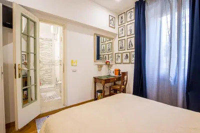 a bedroom with a bed and a desk and a window at Vatican Rooms Irene in Rome