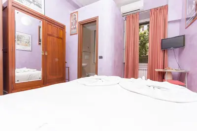 a bedroom with a large bed and a mirror at DomusAmor Colosseo in Rome