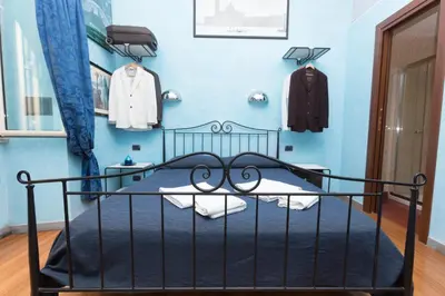 a bedroom with a blue wall and a bed at DomusAmor Colosseo in Rome