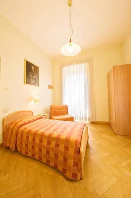a bedroom with a bed and a chair in it at Gästehaus Deutscher Orden in Rome