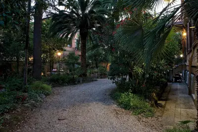 a gravel path in a garden with palm trees at Gästehaus Deutscher Orden in Rome