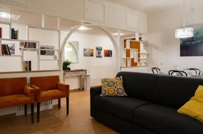 a living room with a black couch and chairs at A casa di Rosanna in Rome