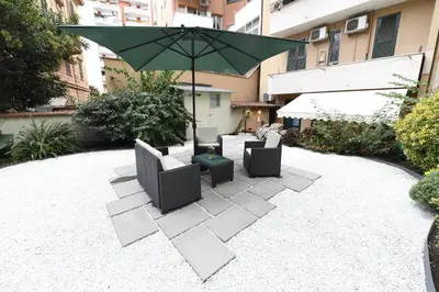 a patio with two chairs and an umbrella at Il giardino nascosto in Rome