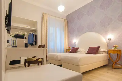 a hotel room with two beds and a mirror at Ripetta Rooms in Rome