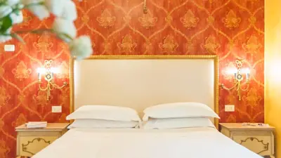 a bedroom with a white bed with two night stands at Ripetta Rooms in Rome