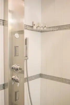 a shower in a bathroom with white tiles at Ripetta Rooms in Rome
