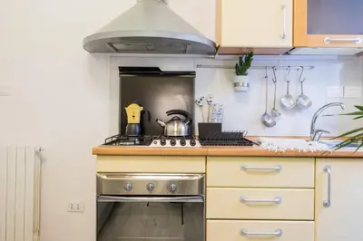 a kitchen and a living room with a table and chairs at Colosseum/Panisperna Nina apartament with terrace in Rome