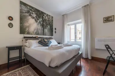 a bedroom with a bed with a large painting on the wall at Quiet and classic on two floors, by Trevi Fountain - FromHometoRome in Rome