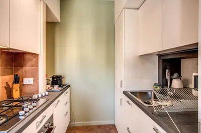 a kitchen with white cabinets and a sink at Roof top dream piazza del popolo in Rome