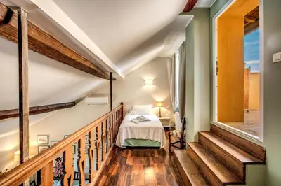 a bedroom in a house with a bed and stairs at Roof top dream piazza del popolo in Rome