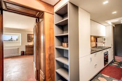 a kitchen with white cabinets and a open pantry at Roof top magic Piazza del Popolo in Rome