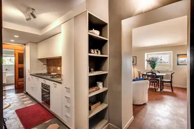 a kitchen with white cabinets and a dining room at Roof top magic Piazza del Popolo in Rome