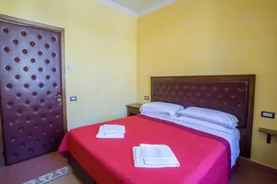 a bedroom with a red bed with towels on it at Anthony Guesthouse in Rome