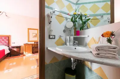 a bathroom with a sink and a bedroom at Anthony Guesthouse in Rome