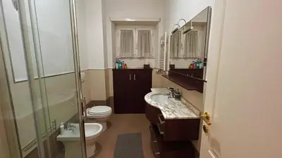 a bathroom with a toilet and a sink and a shower at FG St Peter's Suites in Rome