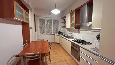 a kitchen with a wooden table and a counter top at FG St Peter's Suites in Rome