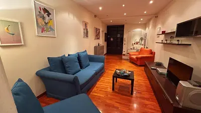 a living room with a blue couch and a tv at FG St Peter's Suites in Rome