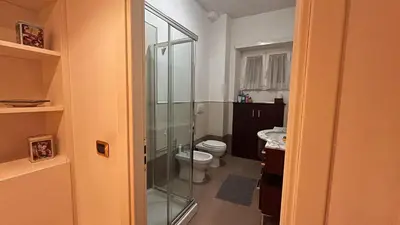 a bathroom with a toilet and a glass shower at FG St Peter's Suites in Rome