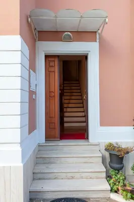 a staircase leading to a house with a brown door at I Villini del Pigneto in Rome