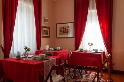 a dining room with red clothed tables and windows at I Villini del Pigneto in Rome