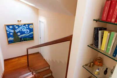 a staircase with bookshelves and a painting on the wall at I Villini del Pigneto in Rome
